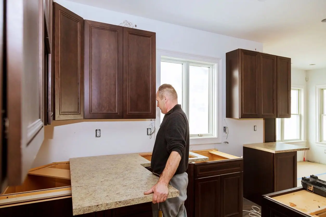 A man in black shirt holding a brown counter top.